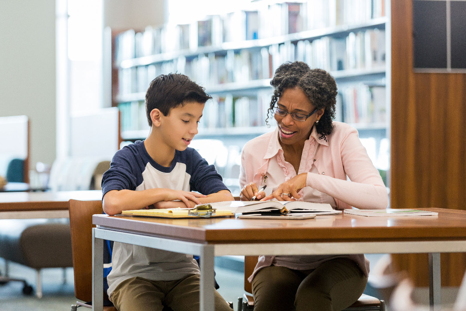 Woman helping a student with his homework.