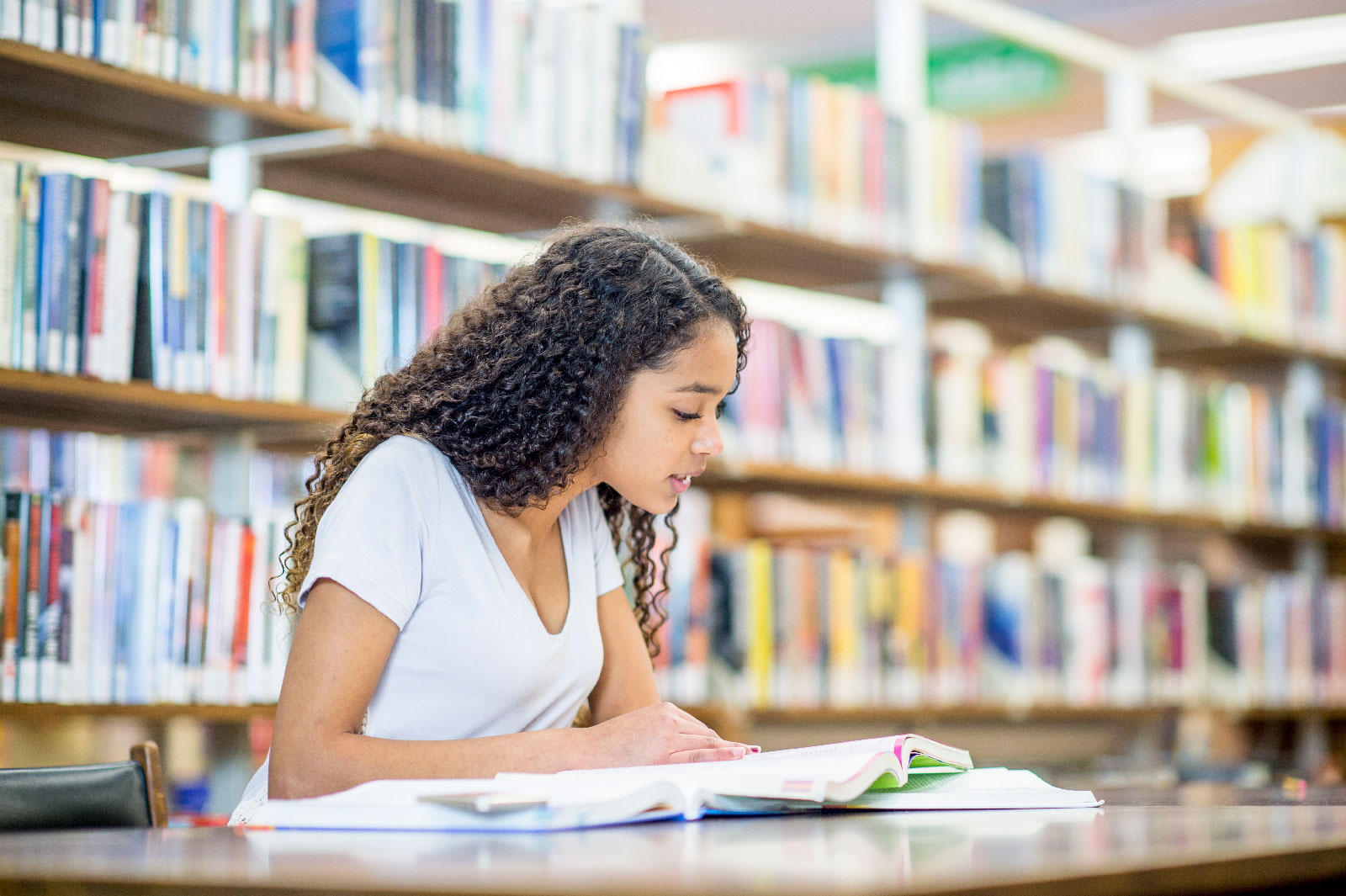 Teenage girl preparing for a test in a library.